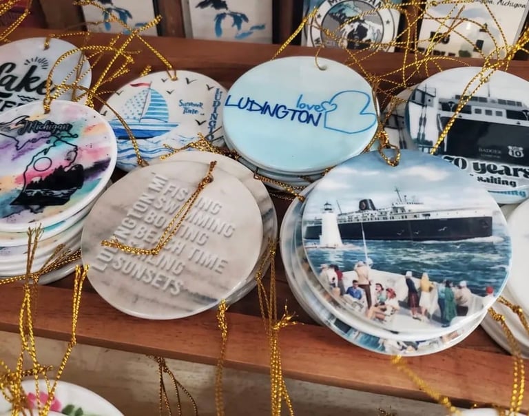 Collection of decorative porcelain ornaments featuring cruise ships and travel themes, hanging with gold strings on a wooden surface