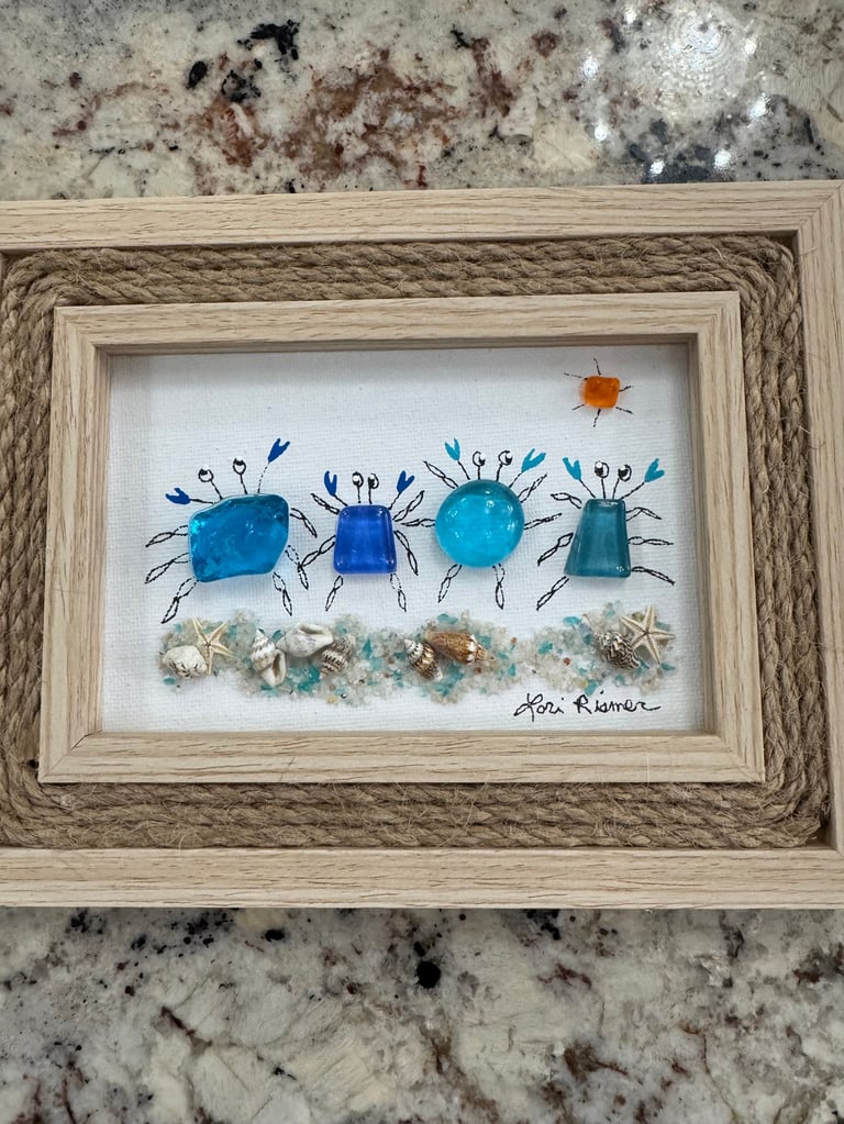 Framed artwork featuring four blue watercolor beetles with thin legs in a row, a small orange sun, and shells along the bottom on white background