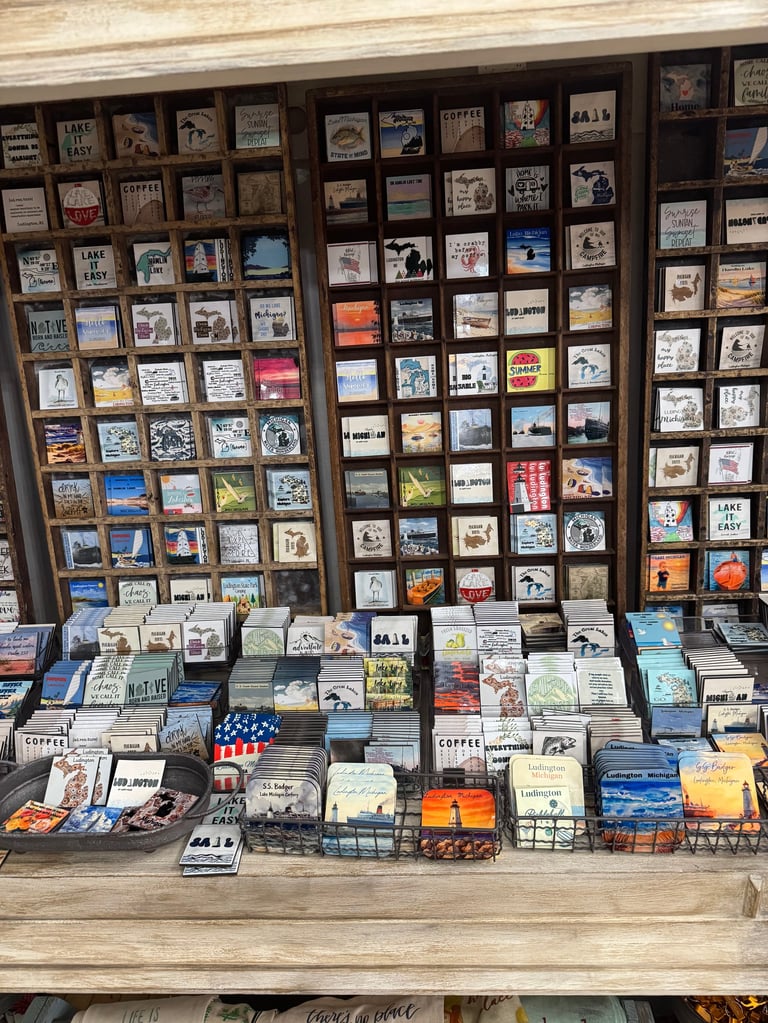 Display case of vintage postcards and printed materials organized in wooden compartments with additional items on the shelf below.